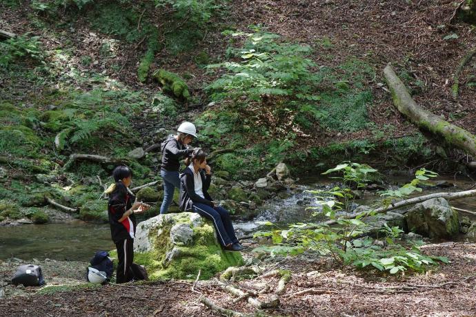 写真:森の中で脳波を測定する学生
