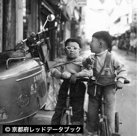 子どもが「月光仮面」に扮(ふん)して三輪車にまたがっている