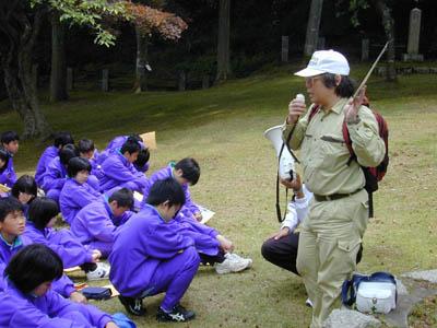 指導員が中学生に対して森林のはたらきを説明しています。