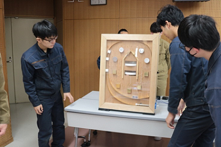 修了課題の製作物を実演しながら紹介している写真