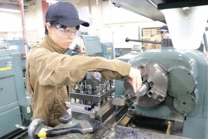 旋盤に取り付けた鉄の部品を測定している様子