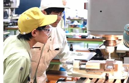 指導員とともに旋盤の動作を確認している様子