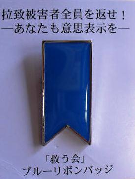 ブルーリボンバッジです。ブルーリボンバッジを着用することで、拉致被害者の生存と救出を信じているという意思表示になります。