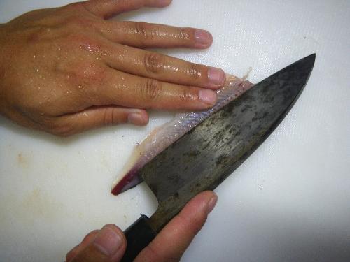 腹骨の付け根に包丁を当てる