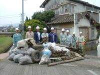 大手川から拾い集めたゴミと清掃作業に参加した職員及び請負者の写真です。